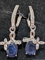 Front view of both earrings showing sapphires, CZ accents and bow motif