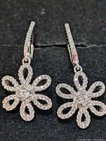 Front view of both earrings showing CZ floral drops and lever-back hooks