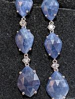Front view of both earrings showing five sapphire stones and accent stones
