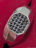 Top view of silver ring showing octagonal face with pavé black diamonds