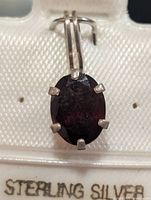 Front view of pendant showing oval garnet and six-prong sterling setting