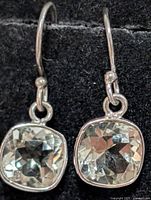 Front view of both silver earrings showing cushion-cut green amethyst stones and French hooks