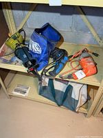 All items on shelf: reciprocating saw, drills, screwdriver bag, tool bag