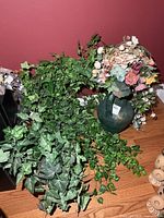 All faux greenery and floral arrangement displayed on wood surface