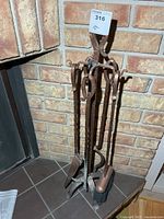 Full view of copper-tone fireplace tool set on stand
