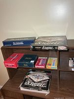 Shelf with Pictionary, Scrabble standard, Balderdash, Beyond Balderdash and other games visible