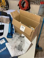 Box on table showing blue hand press and grommets inside