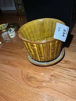 Side view of bamboo-relief planter showing glaze and saucer