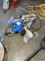 Top view of blue and silver Kobalt compound miter saw with cord