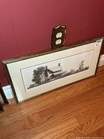 Full view of framed etching against wall