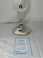 Full view of angel figurine with certificate of authenticity