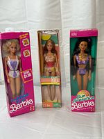 Front view of three boxed dolls: Fashion Play Barbie, Skipper Rio, Sun Sensation Kira