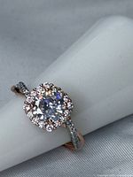 Top view showing round CZ center and halo on twisted two-tone band