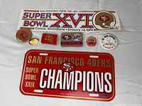 Overview of bumper sticker, license plate, five pins and matchbook