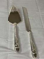 Front view of cake server and knife showing entwined hearts handles