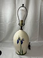 Full view of ceramic table lamp with harp and bulb