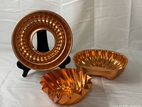 All three copper-tone aluminum molds together