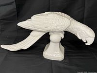 Left-front view of porcelain parrot figurine showing detailed feathers, pedestal base