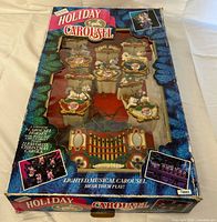 Original printed box showing Holiday Carousel artwork and branding