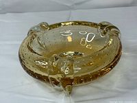 Top view showing amber glass ashtray with bullicante bubbles and three rests