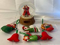 Group shot of snow globe and six fabric ornaments