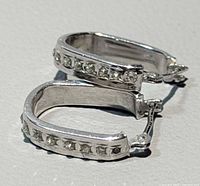 Front view of pair of white gold diamond huggie earrings