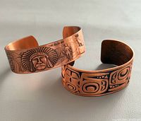Front view showing engraved motifs on both bracelets