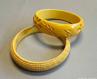 Both yellow Bakelite bangles, carved and textured