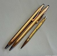 Two gold-filled pens and one gold-plated pencil