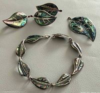Front view of both brooches and bracelet showing abalone inlay and leaf design