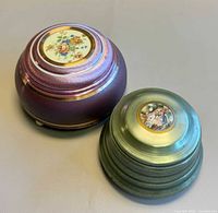 Top view of both closed musical powder boxes showing finishes and porcelain inserts
