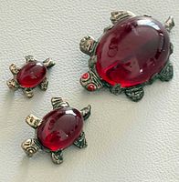 Front view of all three brooches showing design and color