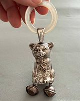 Front view of sterling silver cat rattle with mother-of-pearl ring and bells