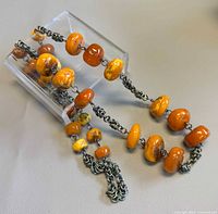 Full view of necklace showing amber beads and chain