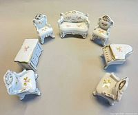 All seven porcelain furniture pieces arranged in a circle