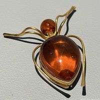 Full view of amber bug brooch showing front design