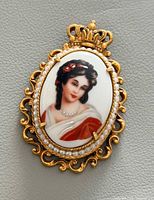 Front view showing portrait, frame, bead border, crown bail