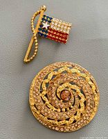 Both brooches: Rafaelian flag and Moo Roo round spiral