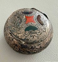 Top view showing engraved lid with red, green and brown cabochon inlays