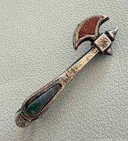 Front view showing axe shape, stone inlays and decoration