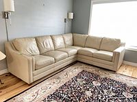 Full view of beige leather L-shaped sectional in corner