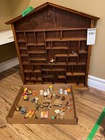 Front view of wooden wall rack and tray of assorted miniatures