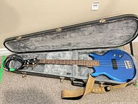 Full view of blue Ibanez bass inside hard case with strap and cable