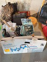 Lot overview showing Swede-Bore auger box, waders, tackle boxes, guides and assorted gear