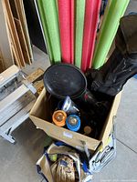 View into box and surrounding area showing black carry bag with ladder frame parts and other items