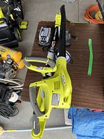 Top view of Ryobi leaf blower with charger and batteries on table