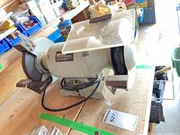 Full view of Shopcraft 8 in. bench grinder showing both wheels, eye shields, tool rests, power cord and mounting base