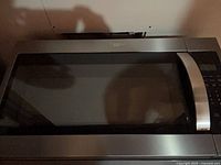 Front view of stainless steel Whirlpool over-the-range microwave with handle and control panel