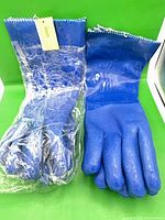 Two pairs blue PVC gloves, one unpackaged and one sealed