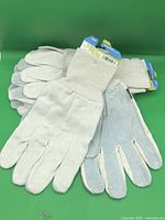 Stack of four pairs of off-white knit gloves with leather palms